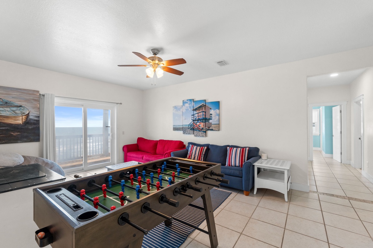 Relax in your bright, comfortable living space with ocean views from the balcony, vibrant seating, and a foosball table for friendly competition.