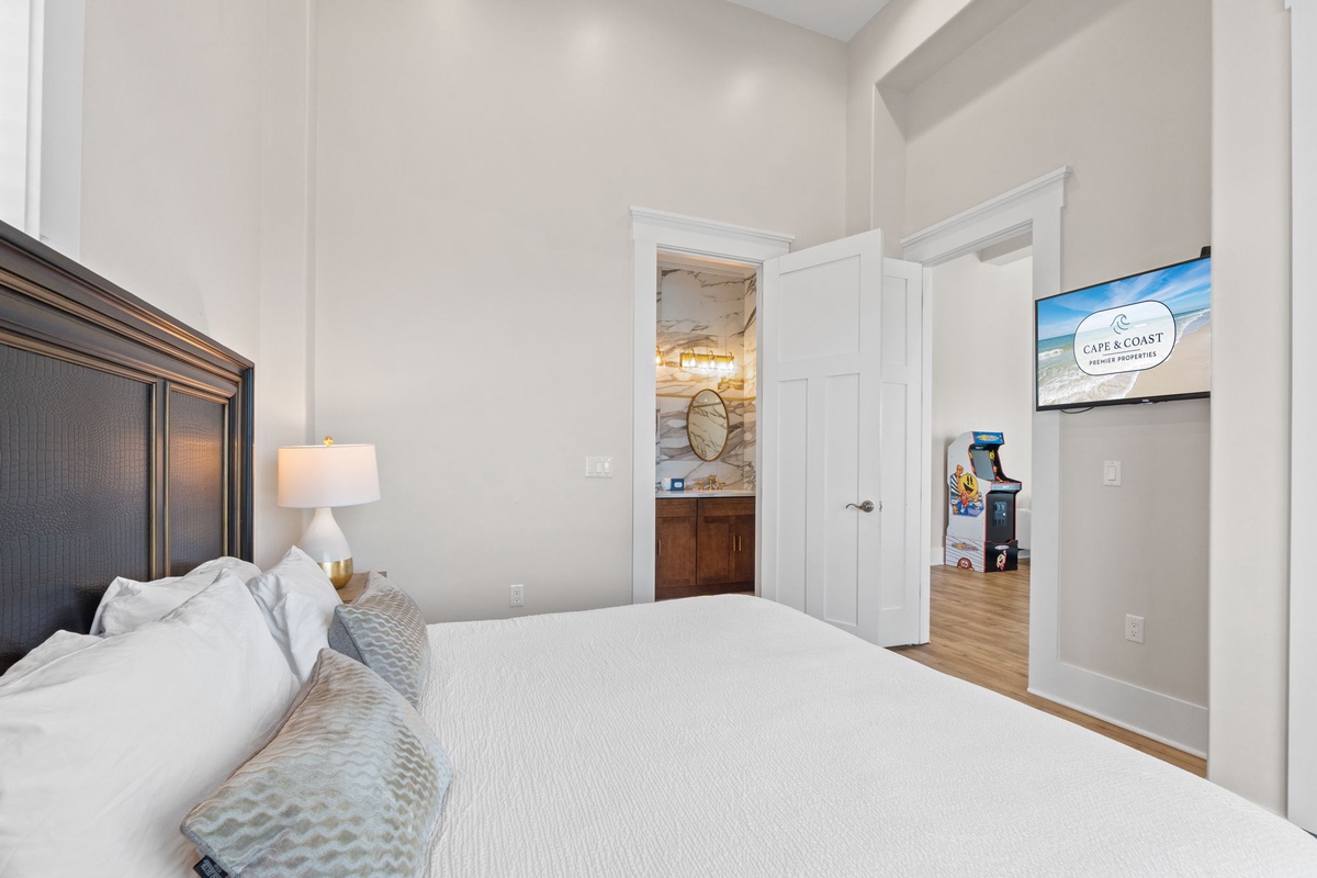 Sink into crisp linens and coastal elegance in your serene bedroom, with convenient access to your private ensuite bathroom.