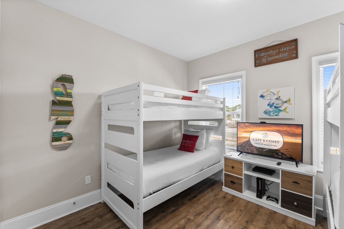 Your kids will love this cozy bunk room, complete with entertainment center and cheerful coastal decor for memorable family adventures.