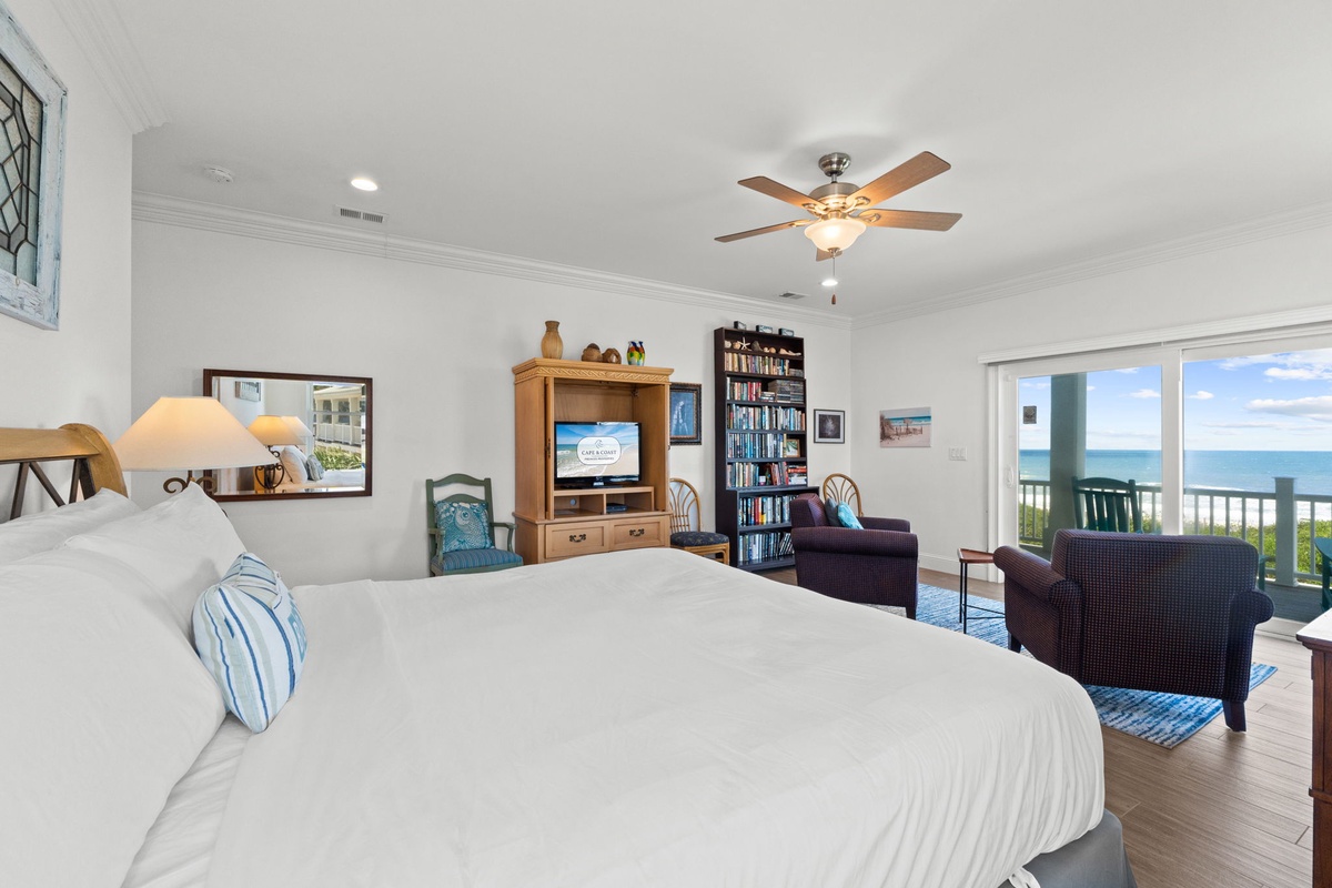 Wake up to stunning ocean views from your spacious bedroom retreat, where a plush bed and cozy seating area invite you to unwind while the sea breeze flows in.