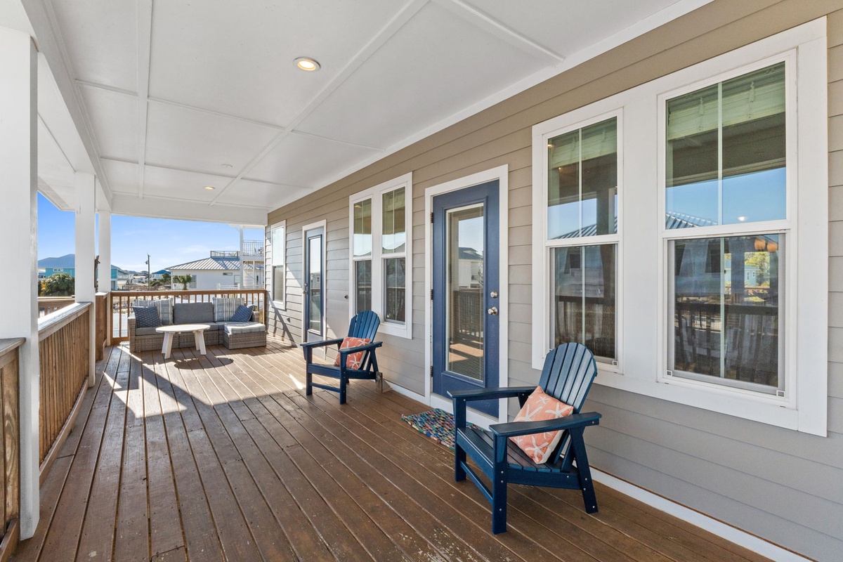 Relax on your spacious covered deck with blue Adirondack chairs overlooking the neighborhood.