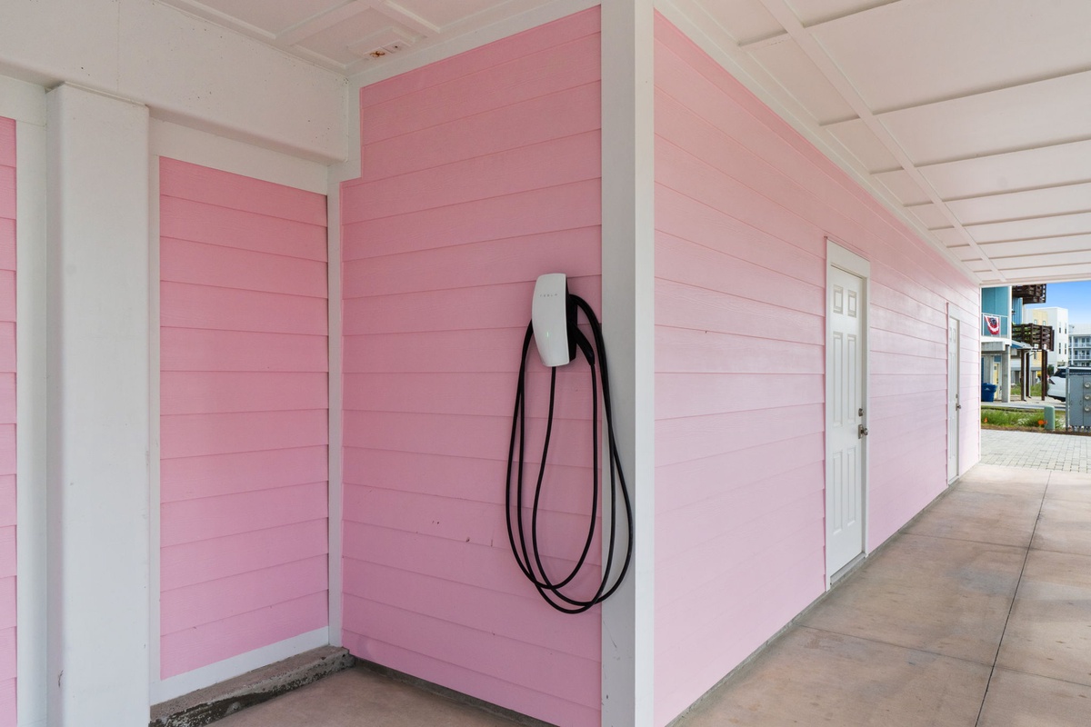 The property's distinctive pink exterior creates a cheerful, welcoming atmosphere as part of the charming coastal neighborhood setting.