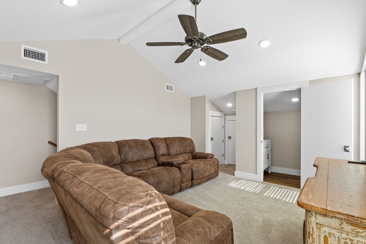 Relax in your spacious living room with plush sectional seating and a gentle ceiling fan to keep you comfortable year-round.