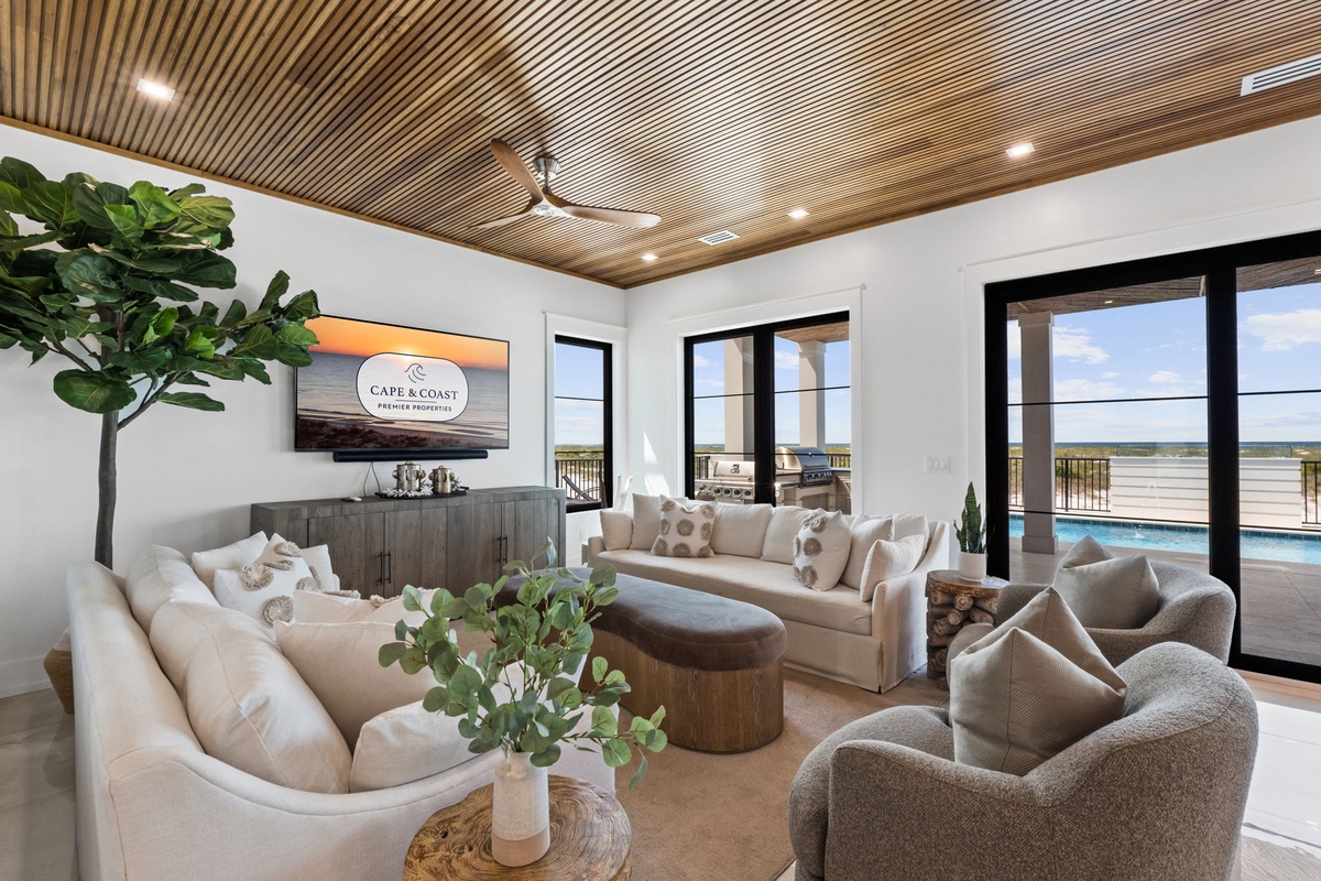 Unwind in your private living room where soaring slatted ceilings and plush seating invite you to relax. Floor-to-ceiling glass doors frame stunning water views and open to your pool terrace.