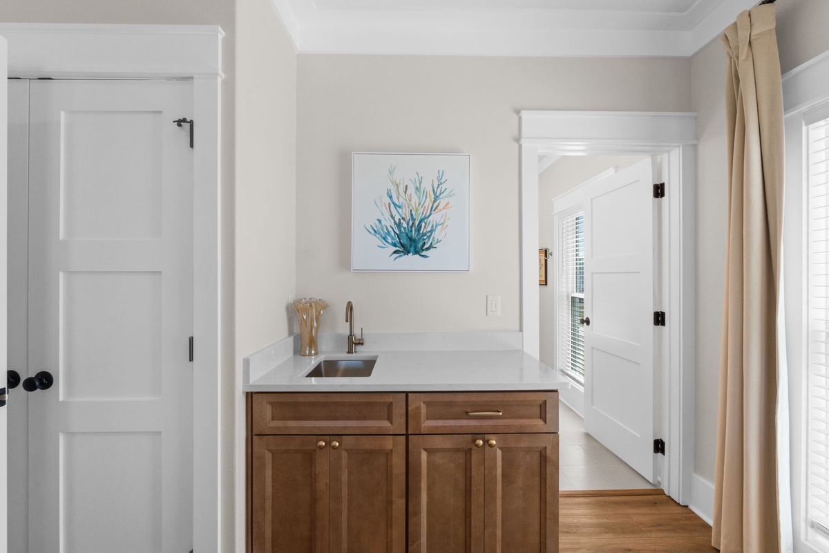 Your own wet bar with a sleek sink and elegant wood cabinetry makes mixing drinks or prepping snacks a breeze in your private retreat.