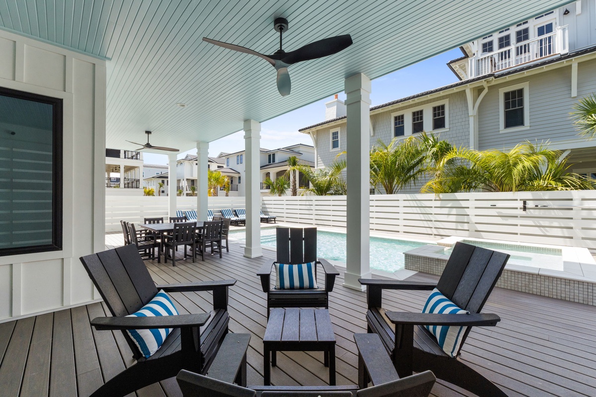 Relax in your private outdoor retreat with poolside seating, dining space, and coastal breezes under ceiling fans. Perfect for morning coffee or sunset gatherings.