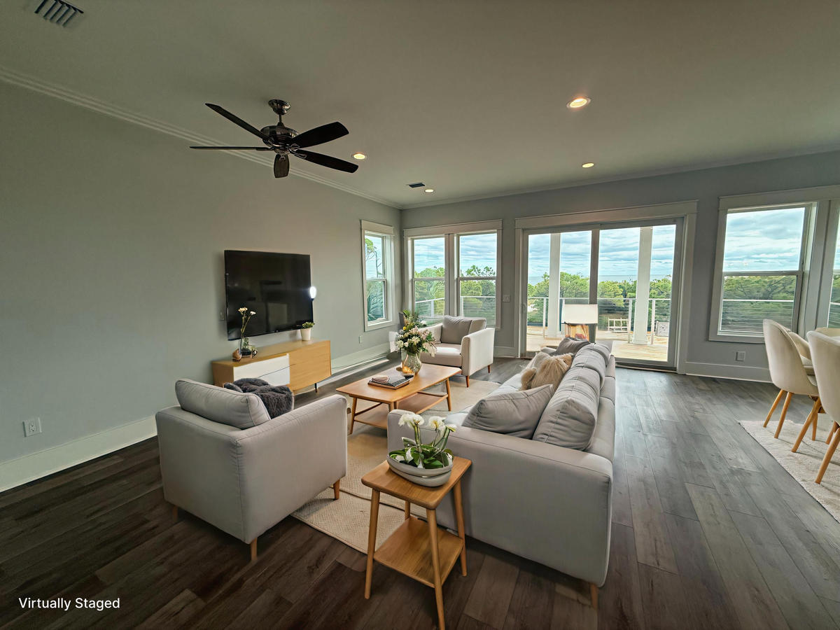 Unwind in your bright, airy living room where floor-to-ceiling windows frame stunning views and modern comfort meets warm wood accents.