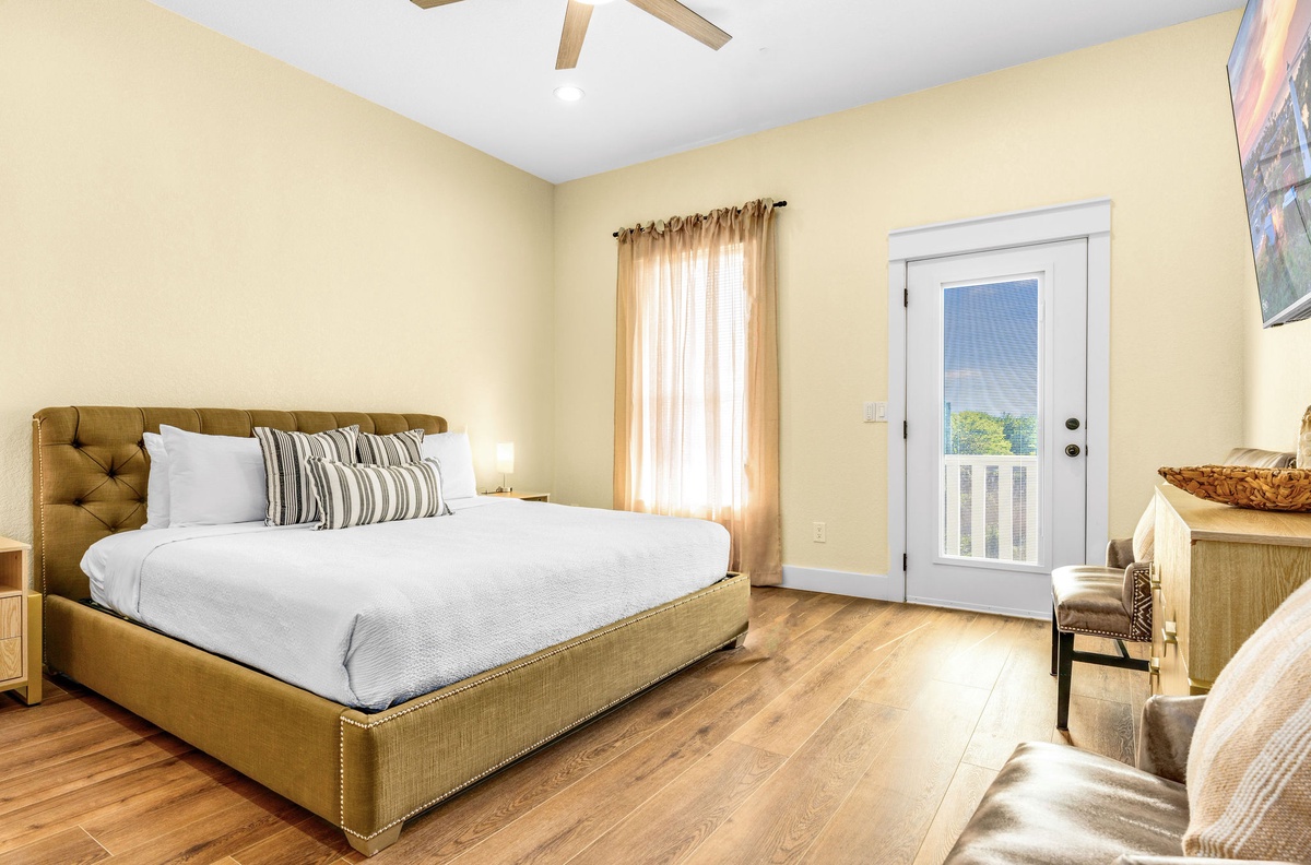 Sink into your plush upholstered bed and wake to natural light streaming through warm curtains in this serene retreat.