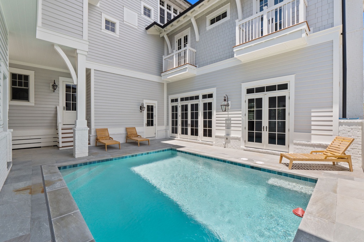 Your private courtyard oasis awaits—dive into crystal-clear waters surrounded by elegant architecture, lounge on the sunny deck, and unwind in coastal-chic style.