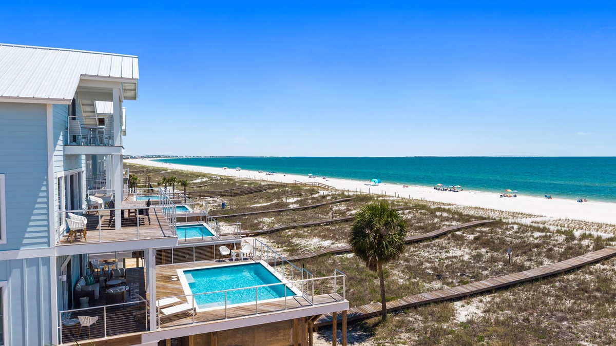 Modern beachfront property featuring tiered pool decks and a prime Gulf Coast location with sugar-white sand and turquoise waters just steps away.