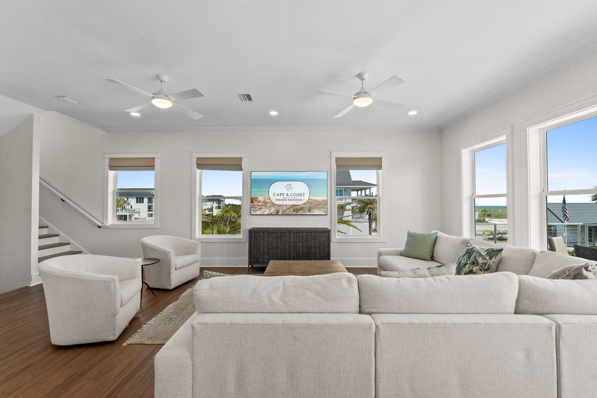 Unwind in your airy, sunlit living room where plush seating invites you to relax, while coastal views through every window bring the serene outdoors in.