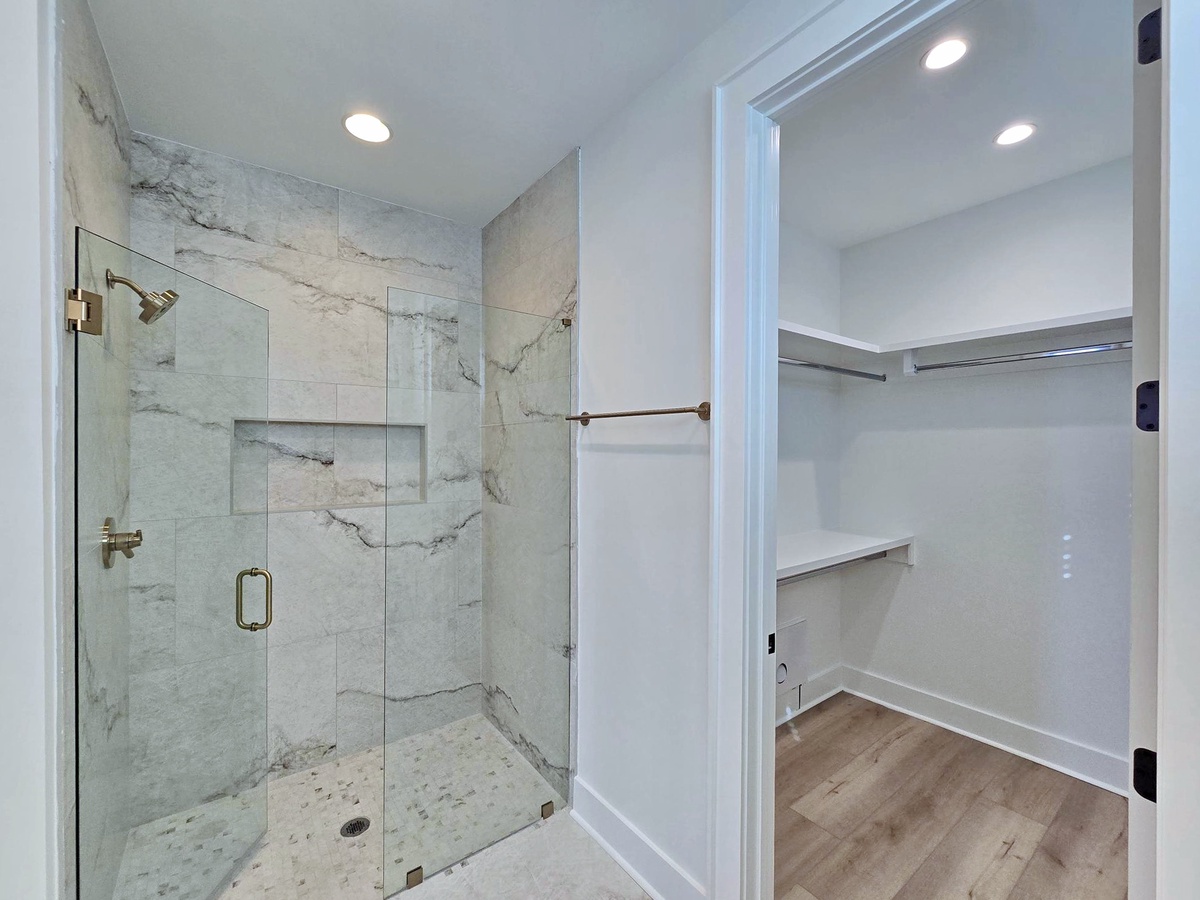 Step into your luxurious marble-tiled shower with modern fixtures, then organize your belongings in the spacious walk-in closet.