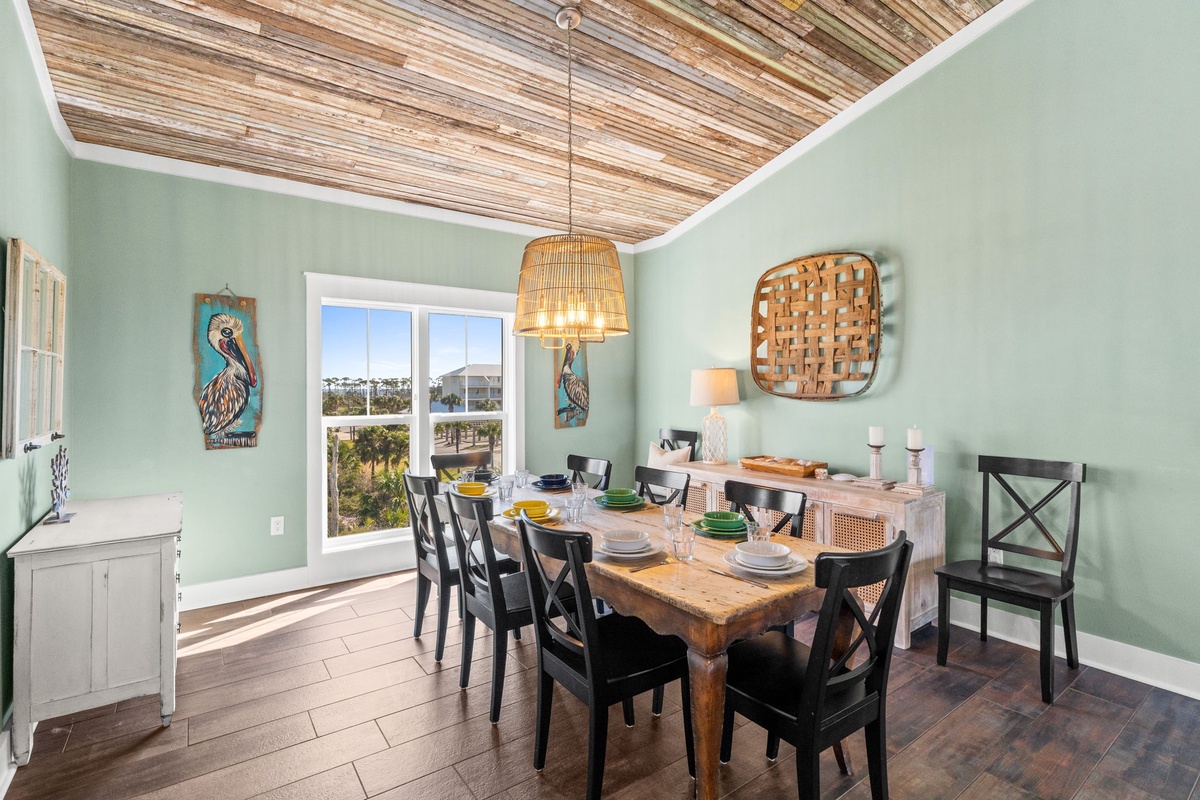 Your dining space features a rustic wood table under coastal artwork, where you'll enjoy meals beneath the stunning bamboo ceiling.