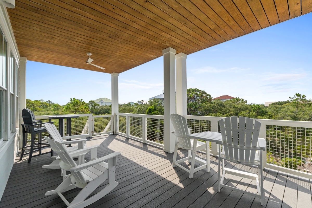 Sink into your private rocking chairs on this spacious covered balcony, where a gentle breeze and lush green views create the perfect retreat for morning coffee or sunset relaxation.