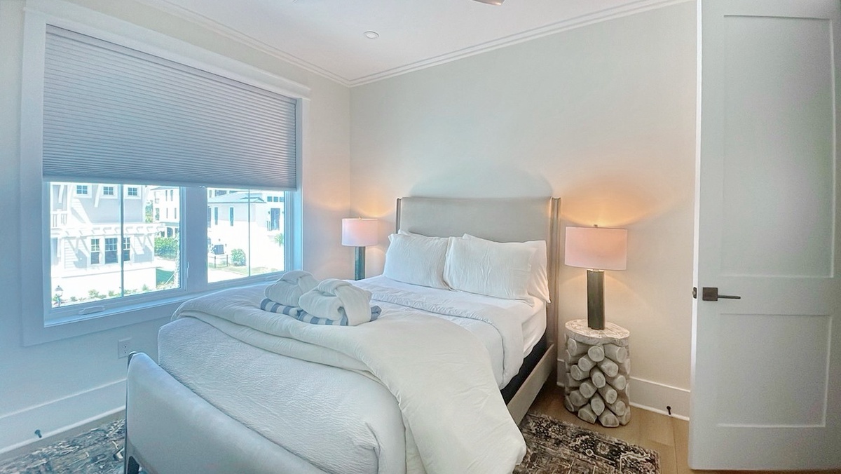 Slip into crisp linens and let soft bedside lighting ease you into relaxation. The large window frames your neighborhood views, while subtle coastal touches remind you why you came.
