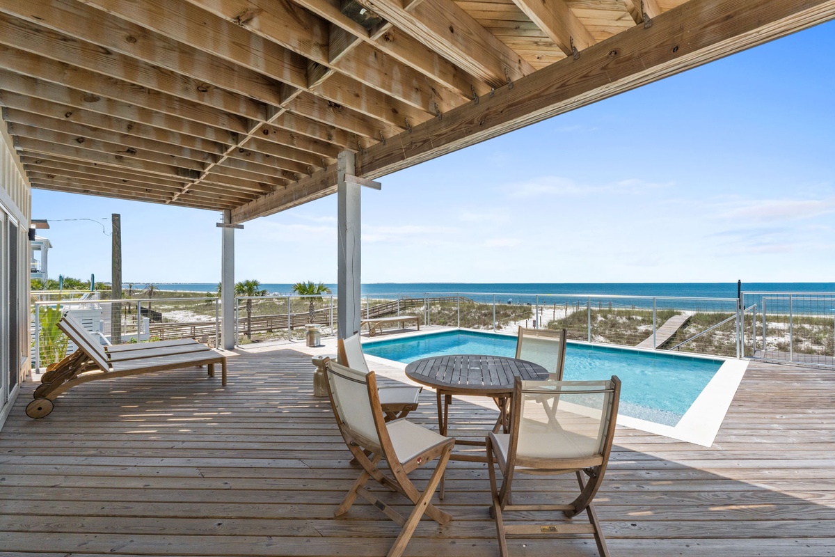 Stunning coastal deck with pool and ocean views frames your perfect beach getaway, where turquoise waters meet sandy shores just steps away.