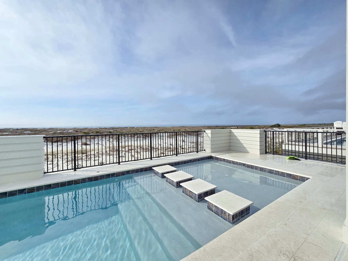 Rooftop pool area with elevated views of the surrounding landscape and open sky above.