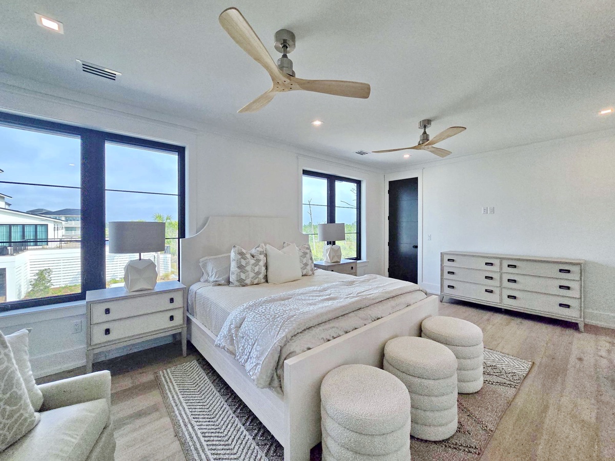 Wake up refreshed in your airy bedroom where natural light floods through oversized windows and gentle ceiling fans create perfect comfort.