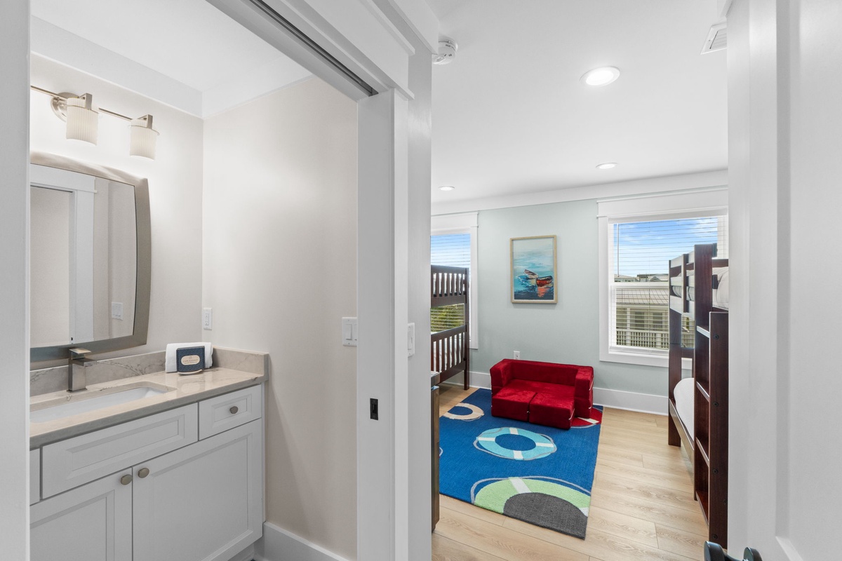 Bright coastal retreat offering your family a cheerful kids' room with bunk beds and playful decor, plus a convenient ensuite for easy morning routines.