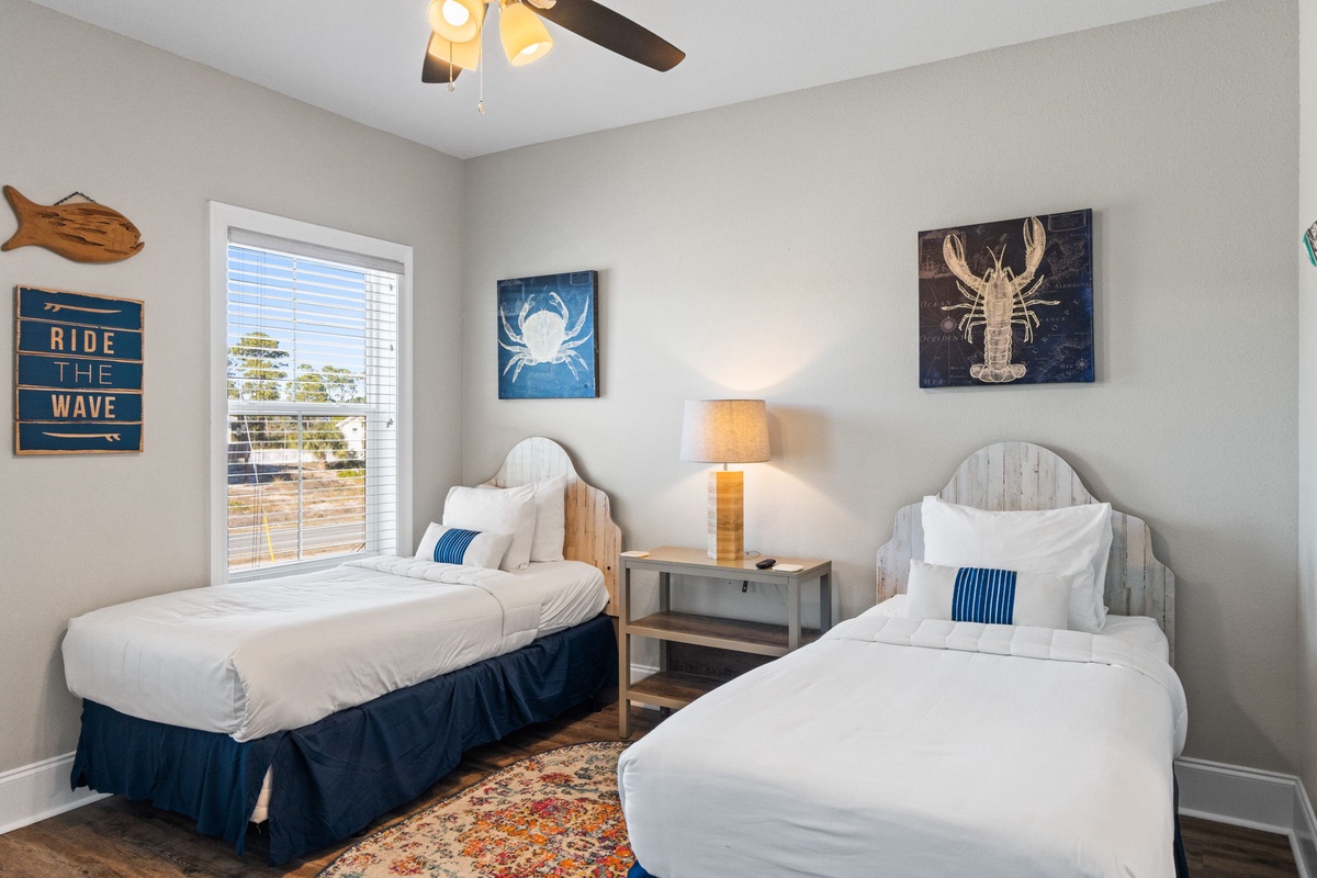 Two comfortable beds with coastal-themed decor create the perfect space for you and your travel companion to unwind after beachside adventures.