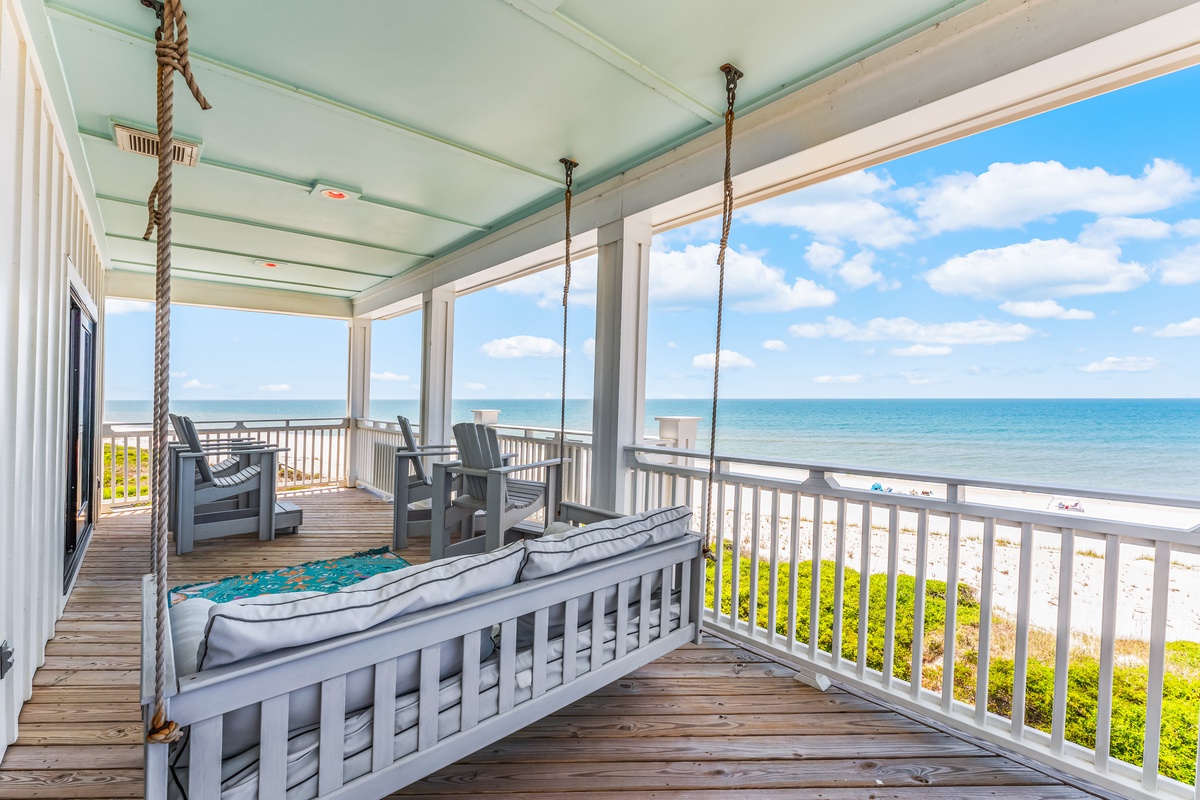 Your oceanfront balcony awaits with a cozy swing bed and sweeping sea views—the perfect spot for morning coffee or sunset relaxation.
