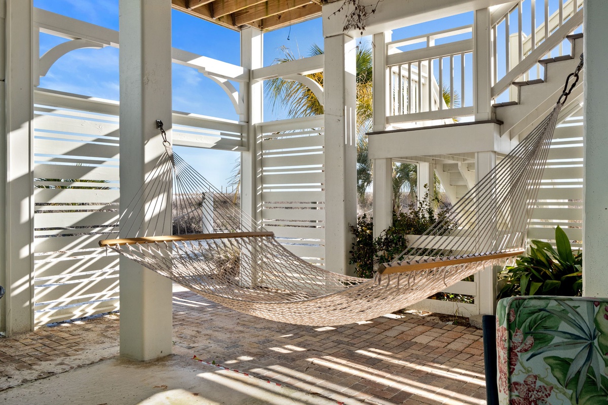 Sway gently in your private hammock while tropical breezes flow through this serene covered terrace, where latticed shadows dance on stone floors.