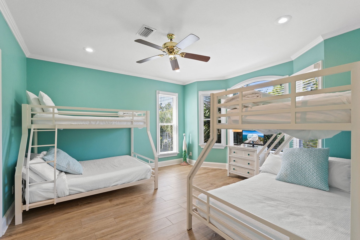 Your kids will love this bright bedroom with cozy bunk beds and entertainment center in soothing turquoise.