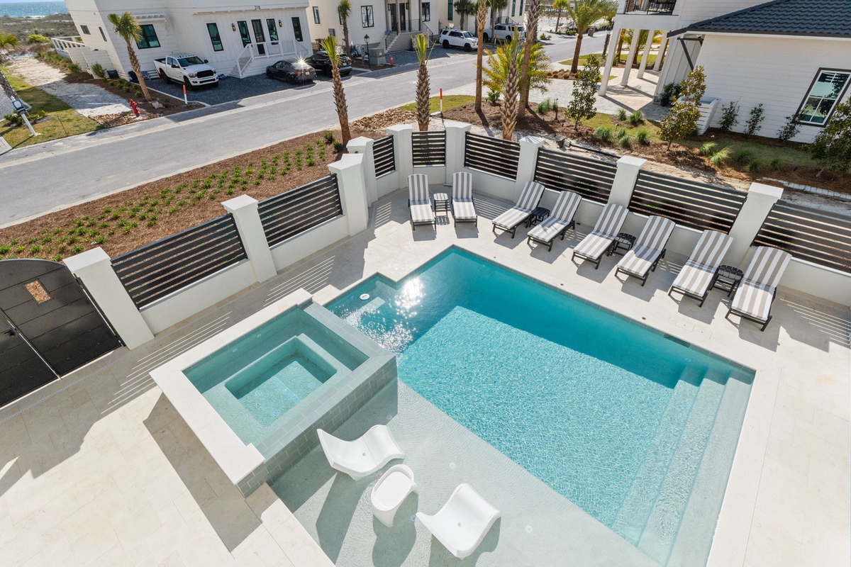 Modern luxury pool complex with hot tub and elegant lounge seating in an upscale residential development.