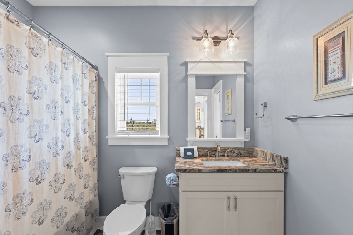 Your bright bathroom features elegant granite counters, crisp white cabinetry, and cheerful natural light from your private window.