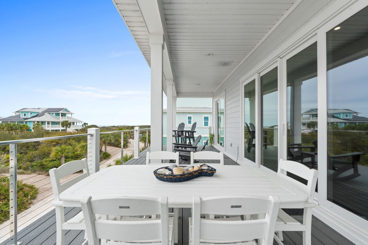 Dine alfresco on your spacious deck with stunning coastal views stretching toward neighboring beach houses and natural dunes.