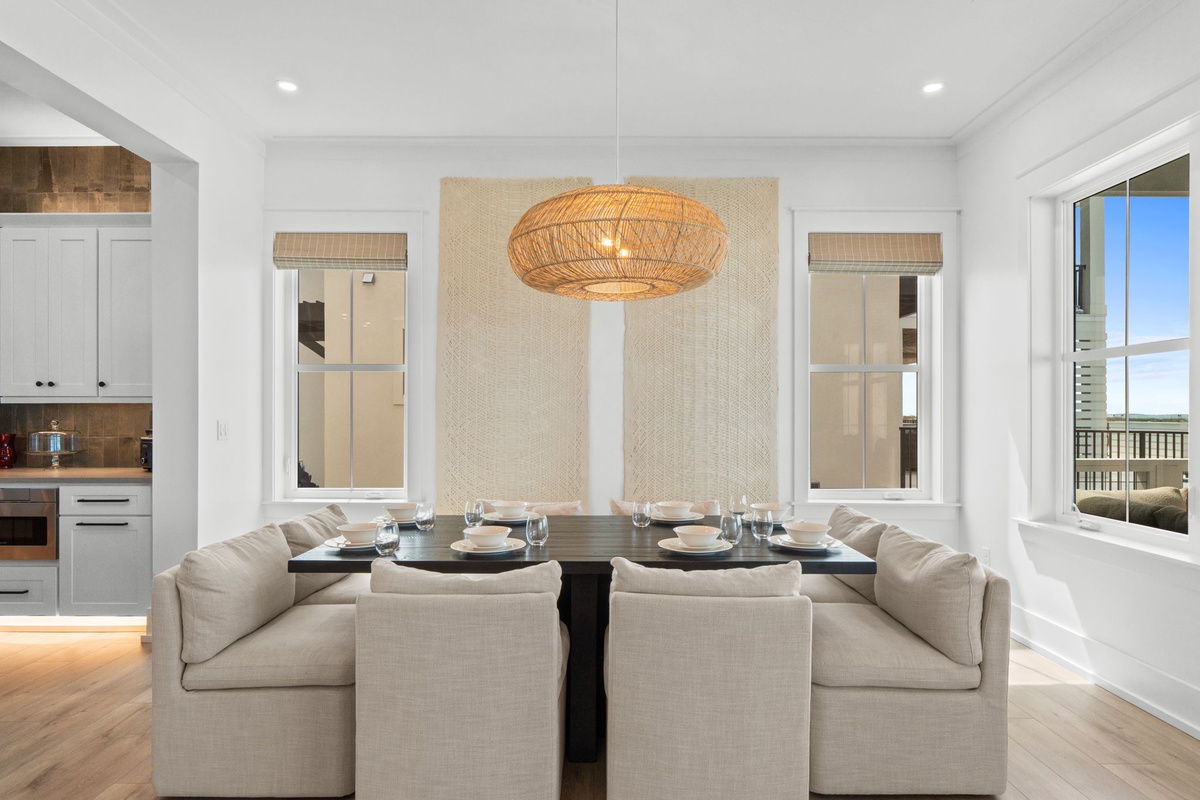 Step into your bright, airy dining space where soft linens meet modern elegance. Gather around this inviting table under warm coastal lighting, perfect for memorable meals together.