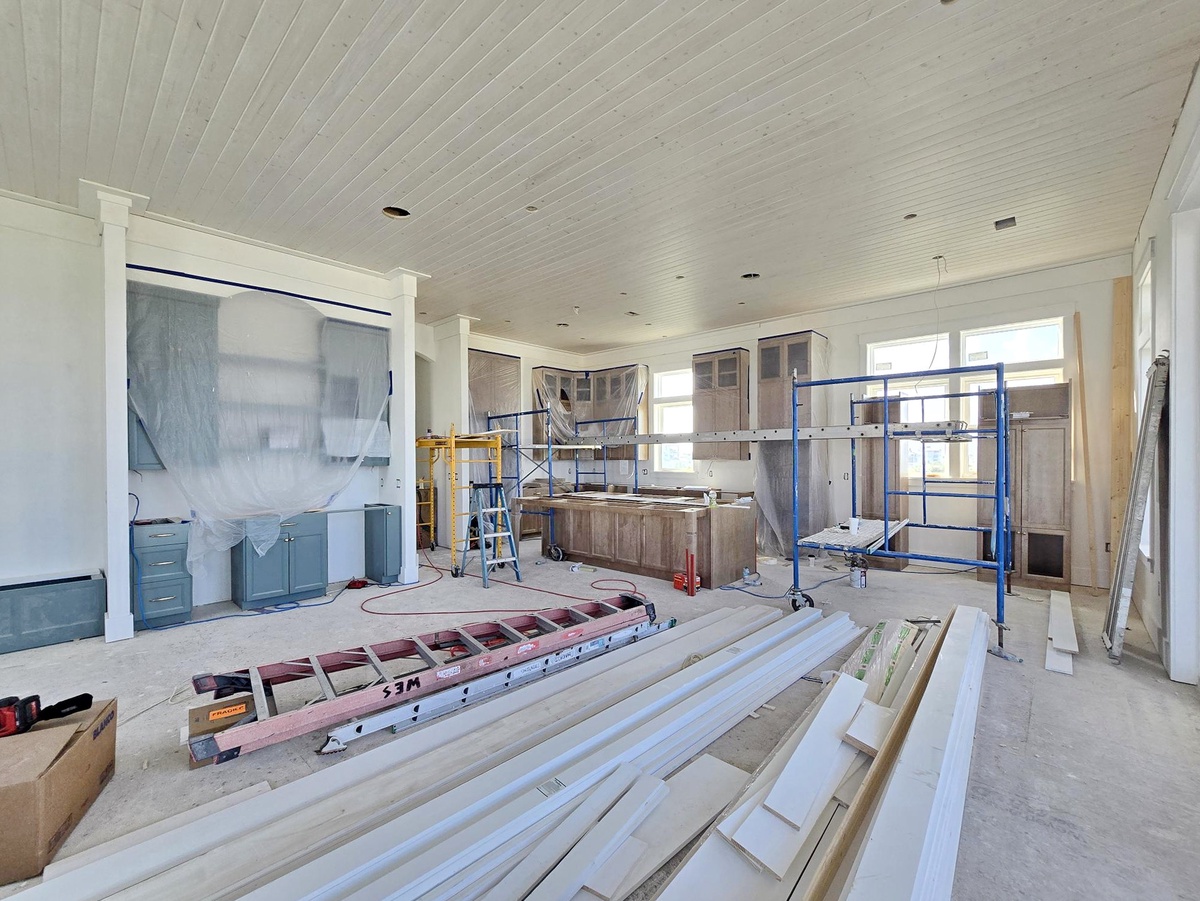 A bright, open space under construction showcasing the expansive layout and thoughtful design, with beautiful beadboard ceilings and custom cabinetry taking shape to create your future dream retreat.