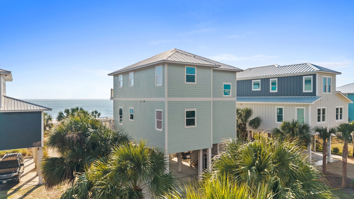 Coastal vacation homes with tropical landscaping near the waterfront, offering a peaceful beachside retreat.