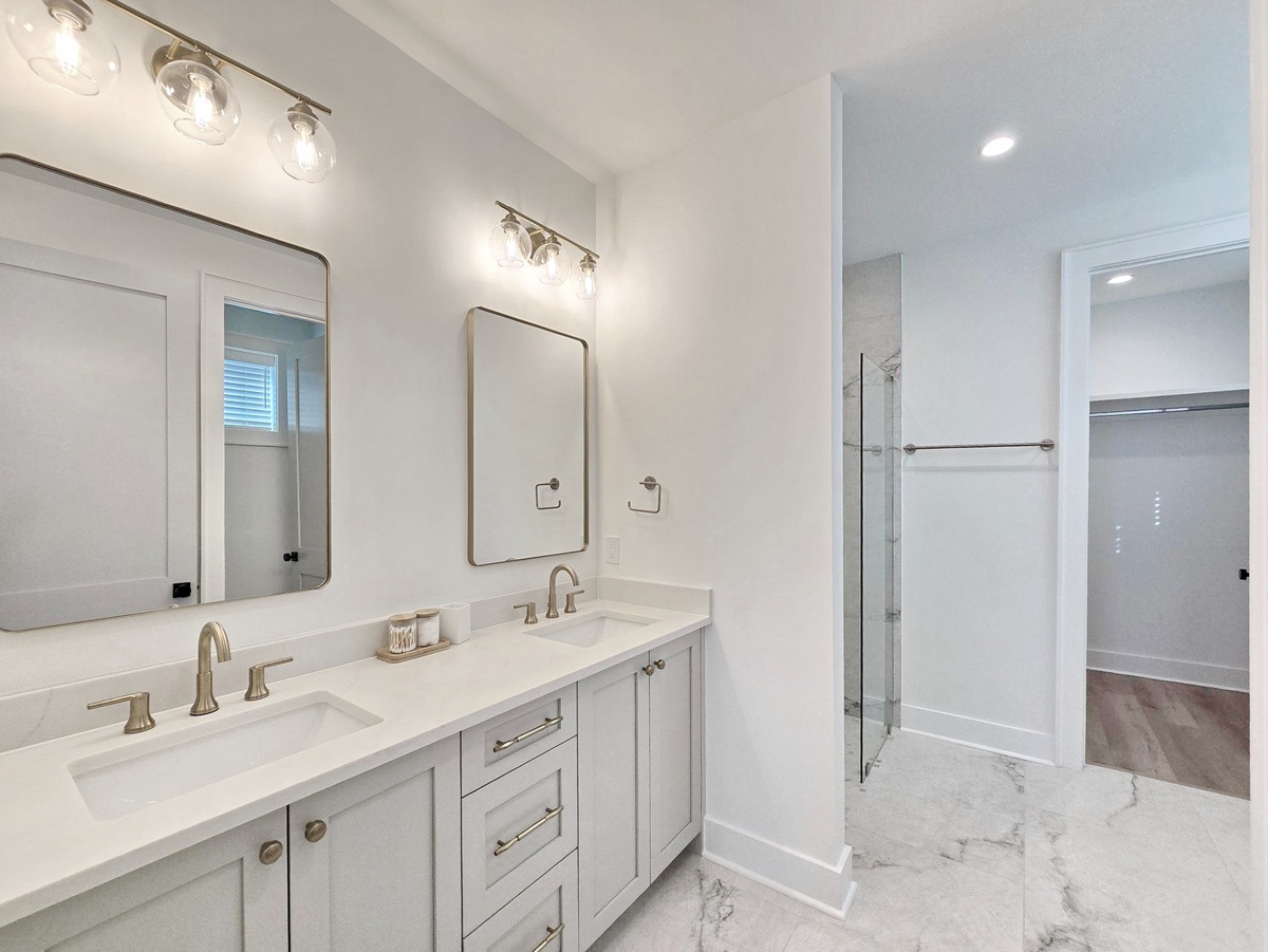 Pamper yourself in this elegant double-sink bathroom with beautiful marble floors and ample vanity space for your daily routines.