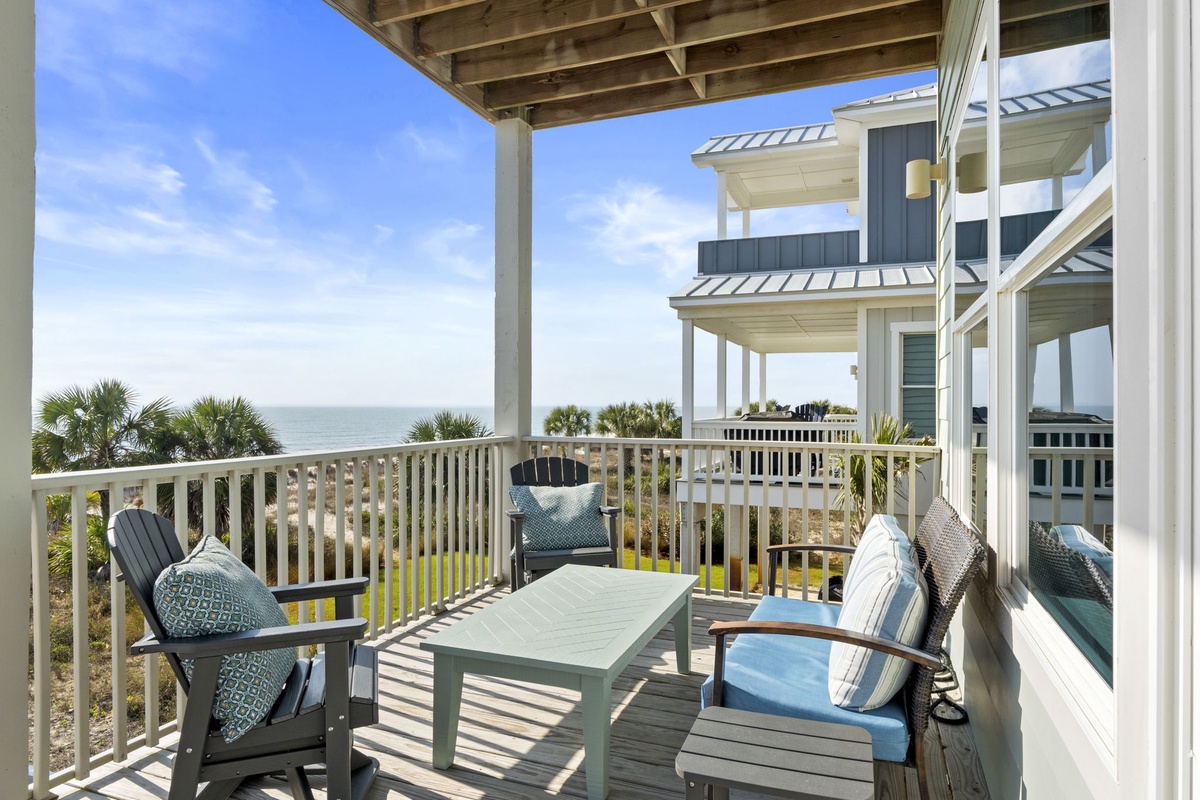 Sip your morning coffee on this spacious covered balcony while soaking in stunning ocean views through swaying palms.