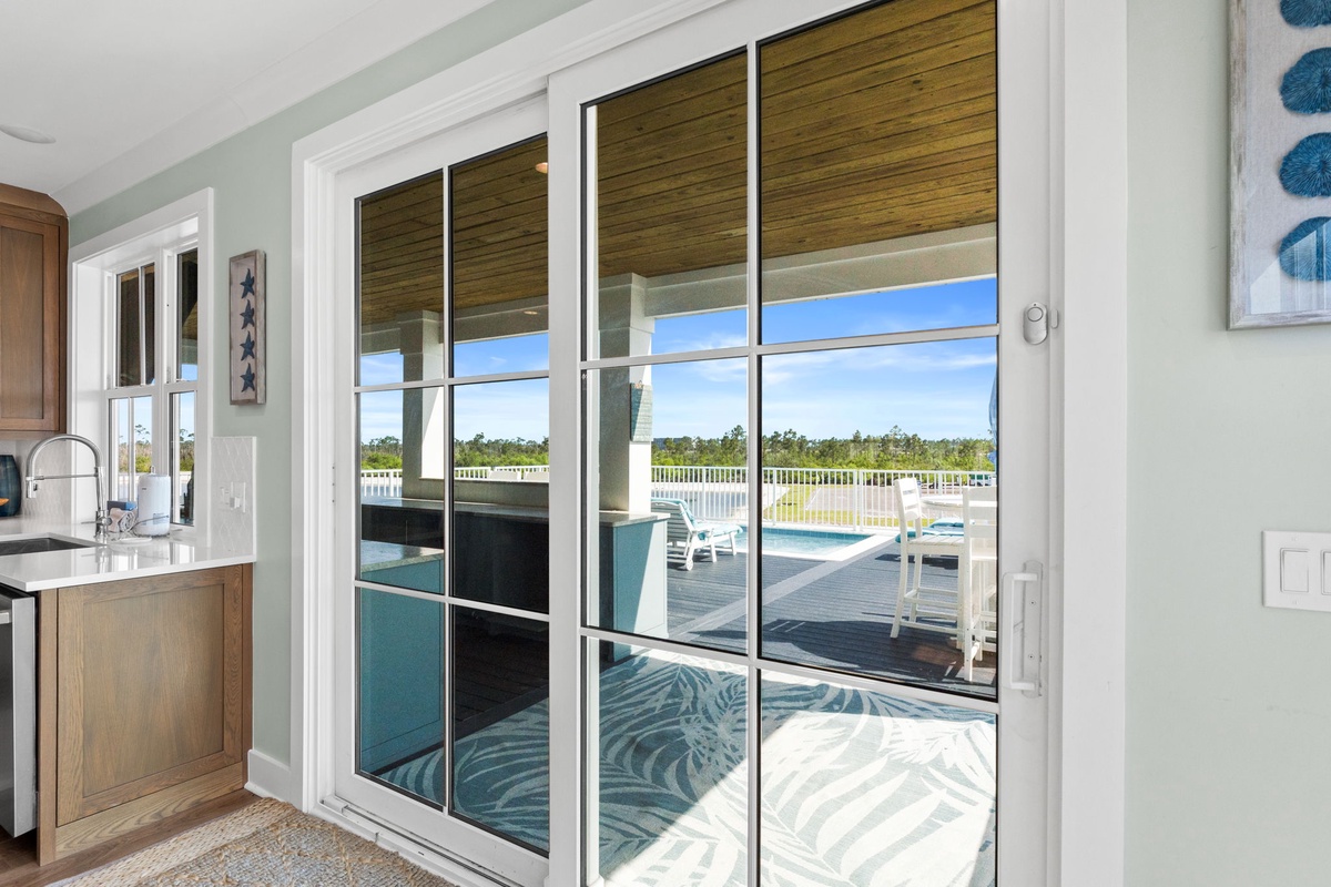 Step into your sun-filled retreat with gorgeous views of the sparkling pool and expansive outdoor deck. The tranquil natural surroundings promise peaceful, unforgettable stays.