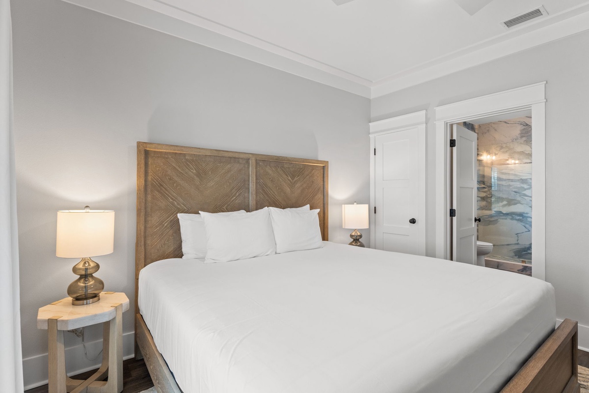 Sink into crisp white linens and wake refreshed in your serene bedroom, complete with warm bedside lighting and an ensuite bathroom just steps away.