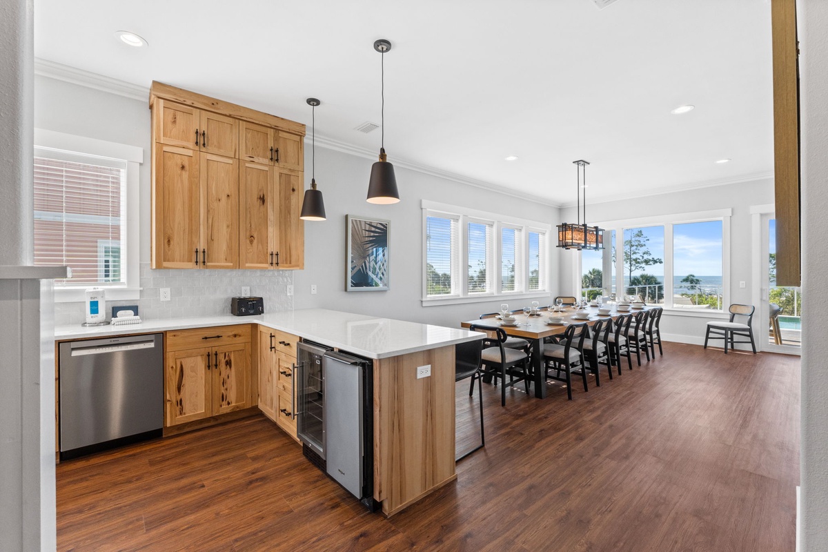 You'll love cooking and dining in this stunning open kitchen with warm wood cabinetry, modern appliances, and panoramic windows.