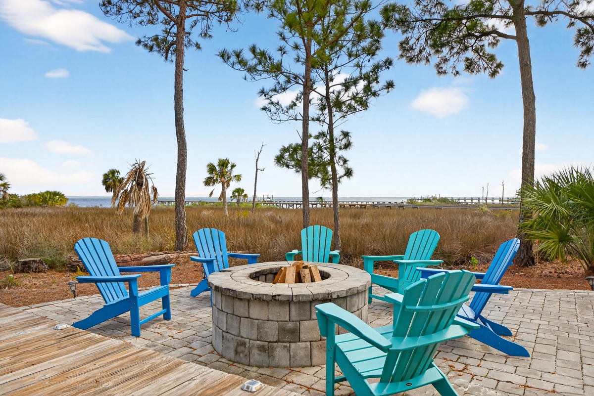 Gather around the stone fire pit in colorful Adirondack chairs, watching sunsets over coastal waters through towering pines.