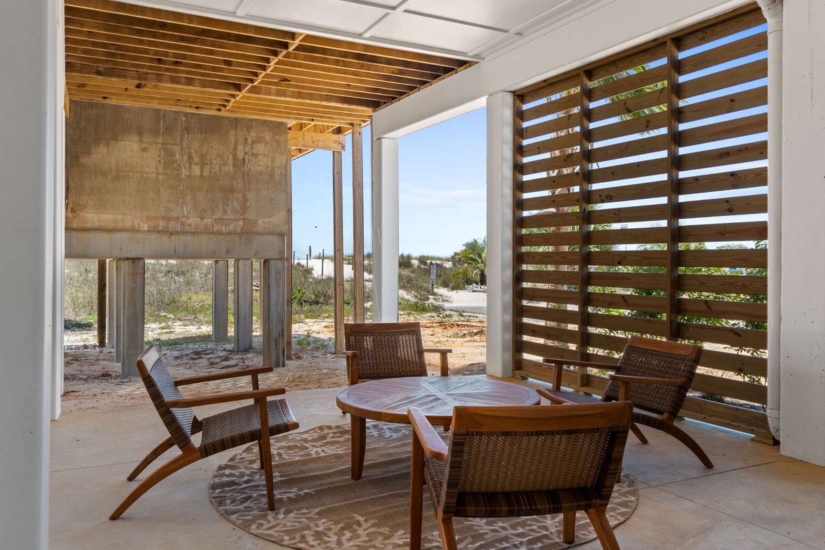 Contemporary open-air seating area framed by desert landscape and natural light through slatted screens.