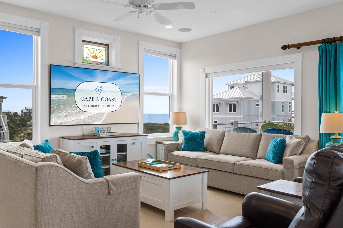 Relax in your bright living room with plush seating and stunning sea views through oversized windows.