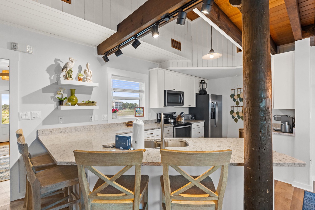Your bright open kitchen invites you to gather around the island, where rustic wooden beams and modern appliances blend effortlessly for a cozy yet refined cooking experience.