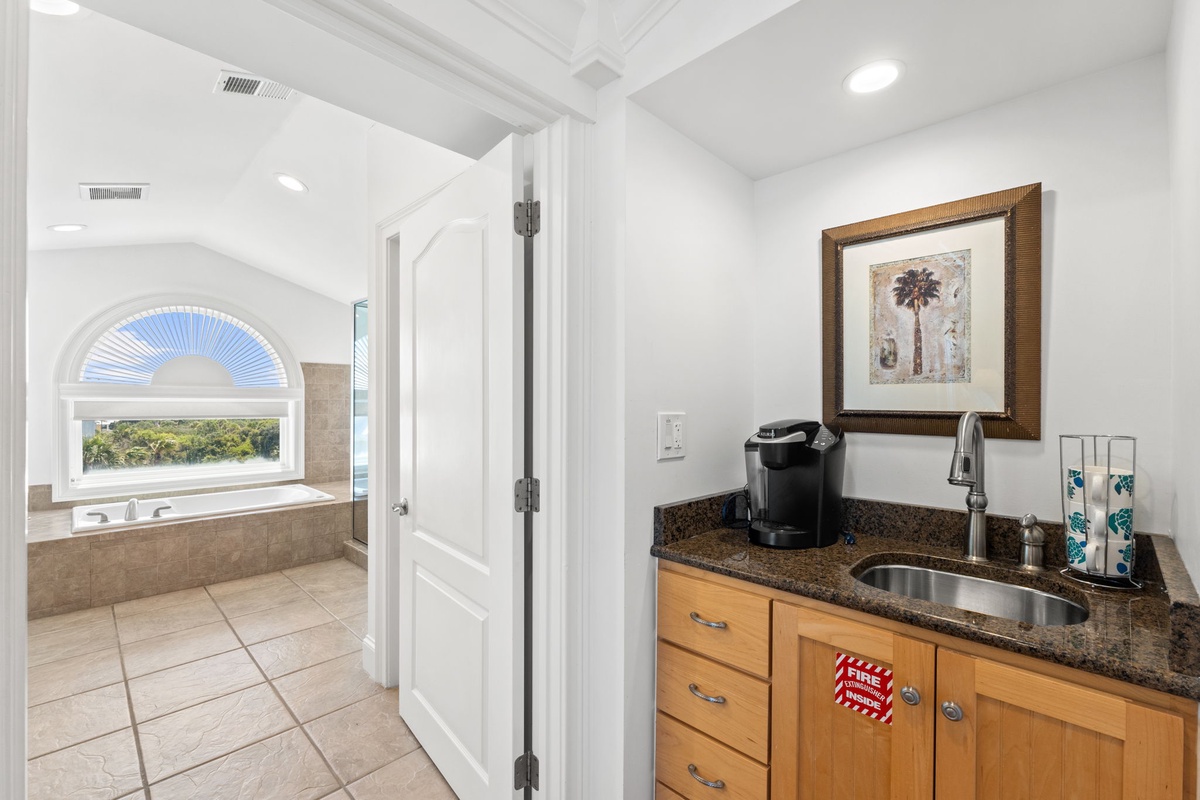 Your private coffee station awaits, complete with granite countertops and everything you need to start your mornings right. Just beyond, enjoy a relaxing soak in your luxurious tub overlooking scenic views.