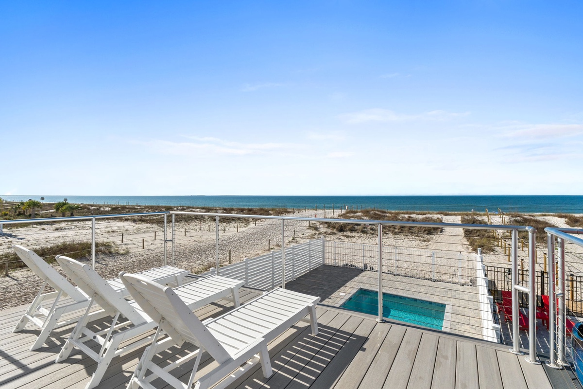 Beachfront property featuring elevated deck with pool, direct beach access, and stunning coastal views.