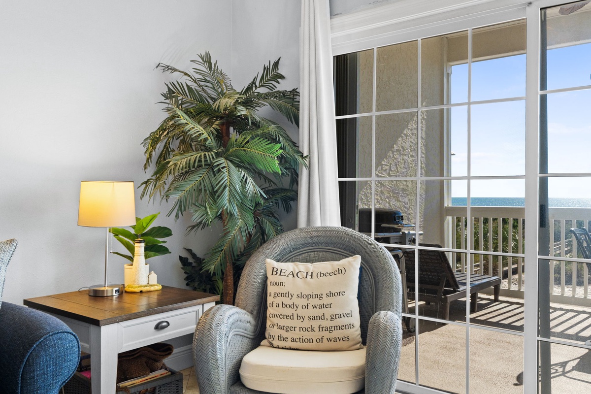 Unwind in your cozy corner with beach-themed décor and natural light streaming through glass doors to your private balcony.