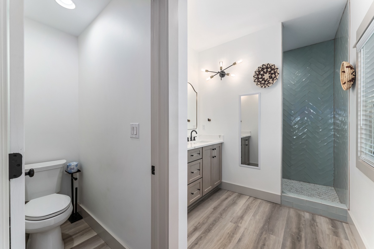 Step into your modern bathroom sanctuary with sleek herringbone tile shower and elegant vanity for refreshing mornings.