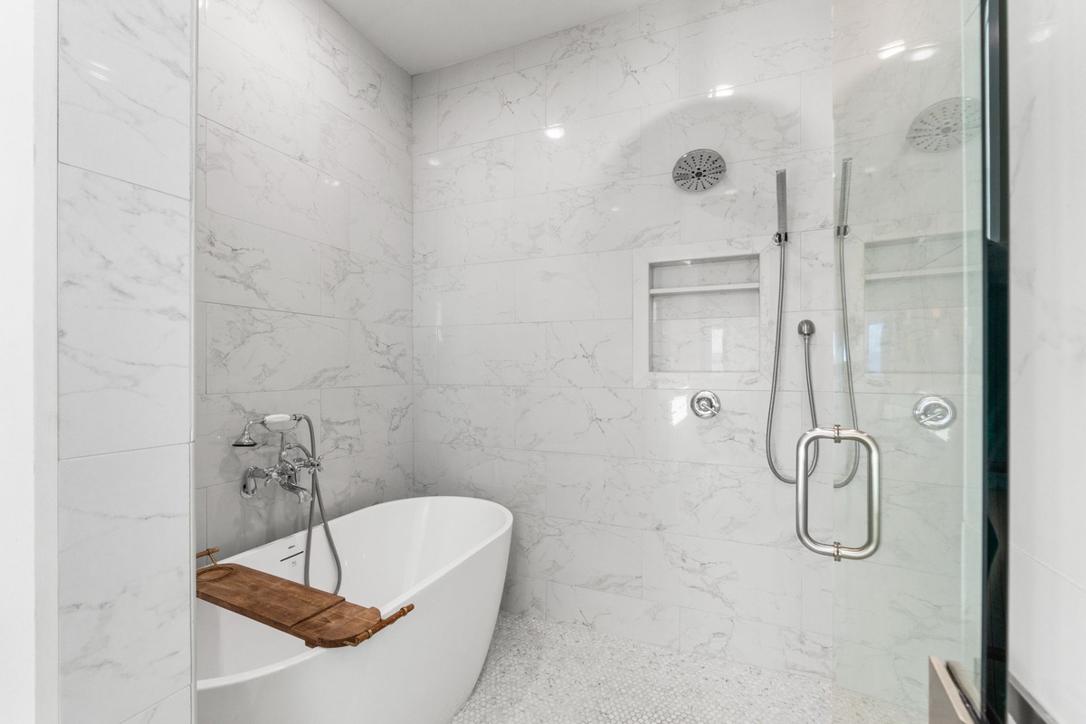 Unwind in your spa-like marble bathroom with a luxurious soaking tub and spacious glass shower for ultimate relaxation.
