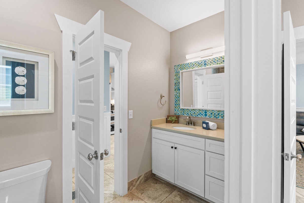 Your private bathroom features a modern vanity with mosaic tile accents, creating a bright and refreshing space for your morning and evening routines.