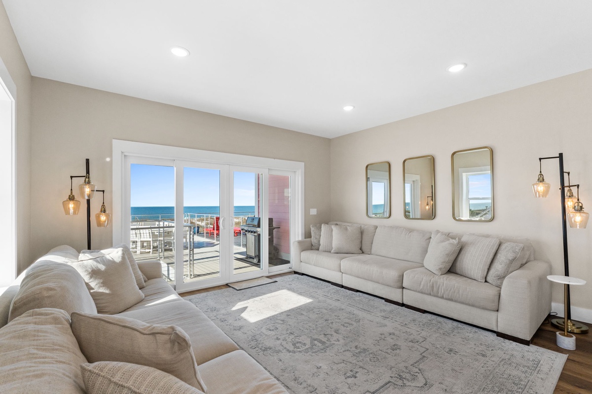 Sink into plush sofas while ocean breezes flow through your private balcony doors, creating the perfect seaside retreat.