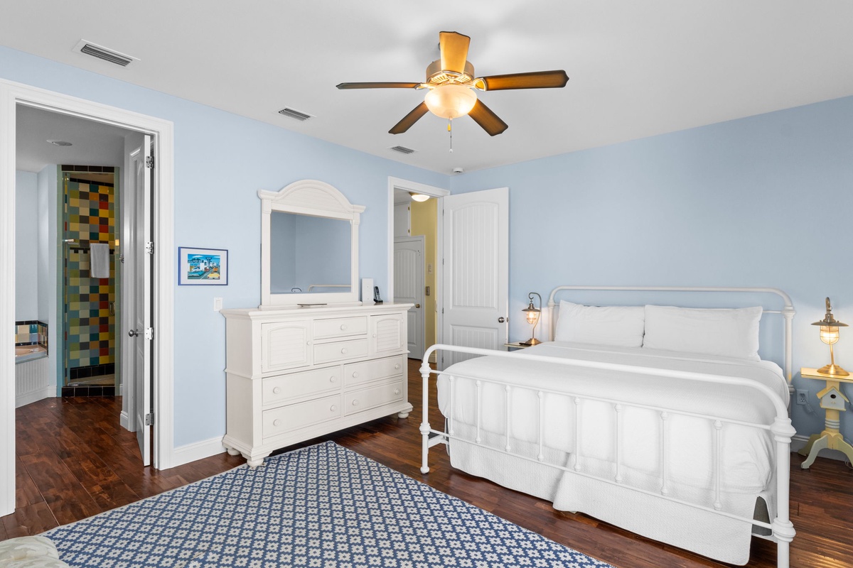 Drift off in this coastal-inspired bedroom where soft blue walls meet crisp white linens. Your private ensuite and ceiling fan ensure comfort after sun-soaked days.